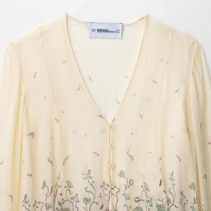 Blouse élégante en mousseline crème avec col en V, boutons et broderies florales