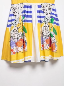 Detail of yellow fruit print dress featuring blue stripes and vibrant summer patterns