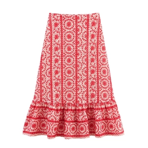 Detail of red floral embroidery on white midi skirt with elegant ruffle hemline