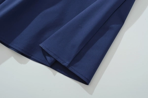 Close-up of high-quality hem stitching and navy blue cotton fabric texture on the dress