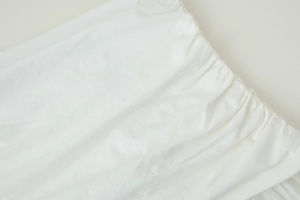 Gros plan détaillé sur les détails de smocks et de plis du tissu de jupe midi blanche