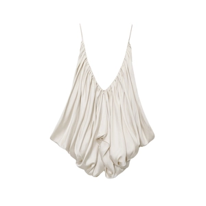 Detail of champagne satin camisole featuring delicate straps and elegant draped pleats