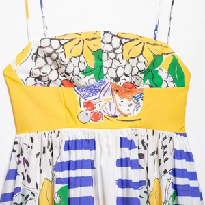 Women's summer dress with colorful fruit print and spaghetti straps on white background
