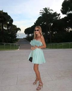 Close-up of mint green floral strapless top and pleated mini skirt set in a garden