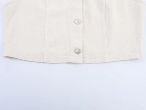 Detail of metal buttons and twill texture on white denim cropped vest for women
