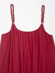 Détail de la robe à bretelles rouge foncé avec perles en tissu et décolleté plissé élégant