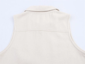 Close-up of the back collar and seam stitching on a beige canvas vest for women
