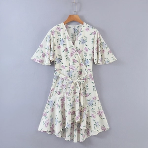 Detail of V-neck floral dress featuring tiered ruffle hem and elegant bell sleeves