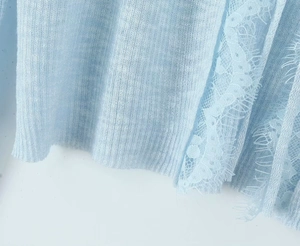 Detail of light blue knit cardigan featuring delicate eyelash lace trim at the hem