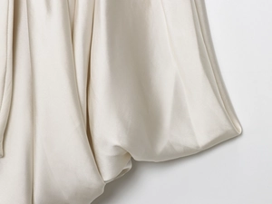 Close-up of champagne satin fabric with elegant drapes and smooth silk texture