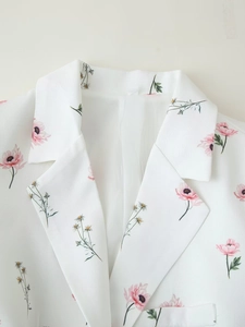 Dettaglio del rever di un blazer bianco da donna con stampa floreale rosa e tessuto pregiato