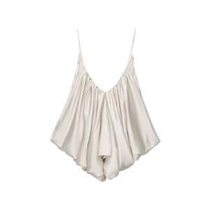 Detailed view of champagne satin camisole featuring delicate pleats and glossy finish