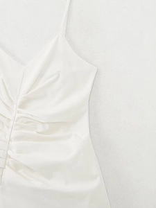 Detailed close-up of white midi dress featuring pleated waist and thin shoulder straps