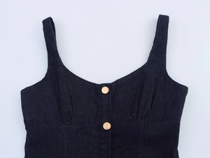 Dettaglio del top in denim blu scuro con scollo a cuore e bottoni dorati lucidi