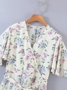 Detail of V-neck wrap dress with floral print, ruffle sleeves and waist tie detail