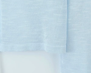 Detailed close-up of light blue knitted mesh fabric with ribbed cuffs for spring jackets