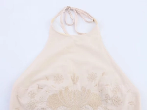Détail de la broderie florale sur un haut dos nu en popeline beige avec liens à nouer