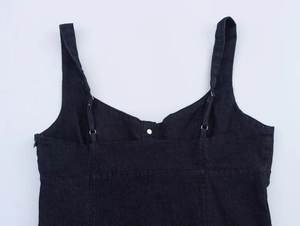 Dettaglio dell'abito midi in denim blu scuro con spalline doppie e rivetto metallico