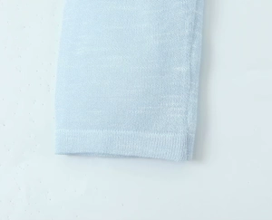 Detailed macro view of the light blue knitted fabric texture and premium sleeve cuff stitching