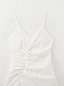 Detailed view of the V-neckline and intricate ruched stitching on a white midi dress