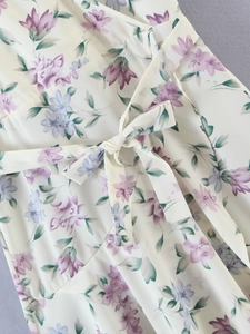 Detailed macro shot of floral print dress with chiffon waist tie and purple flowers