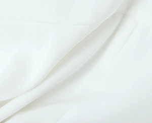 Close-up of premium white fabric texture with soft drapes and fine weave on camisole top