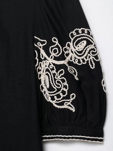 Détail de broderie paisley blanche sur tissu en mélange de lin noir au style ethnique rétro