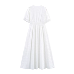 Detail of white cotton maxi dress featuring hollow-out embroidery and puff sleeves