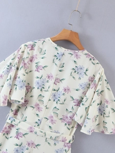 Detail of floral chiffon dress with ruffled sleeves and adjustable waist tie belt