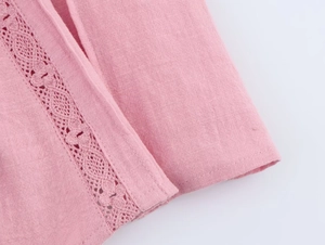 Detail shot of pink cotton-linen fabric featuring delicate crochet lace and fine stitching