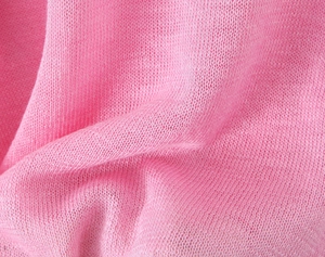 Close-up of pink fine knit fabric with ruffled edge detail and soft textured finish