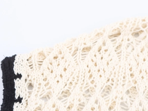 Dettaglio macro della trama in maglia jacquard a rombi traforati con bordo nero a contrasto