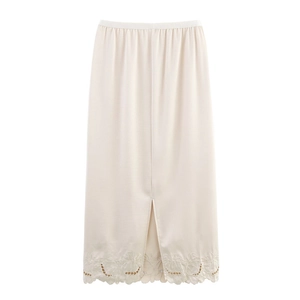 Detail of beige midi skirt featuring floral embroidery, hollow out eyelets and wavy hem