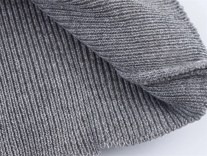 Detailed macro view of the grey ribbed knit fabric texture of this short sleeve sweater