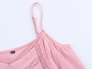 Detail of pink cotton top with delicate lace trim and floral embroidery on neckline