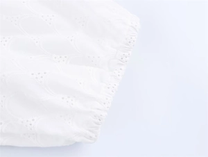 Close-up of white dress sleeve with eyelet embroidery and elastic cuffs for women
