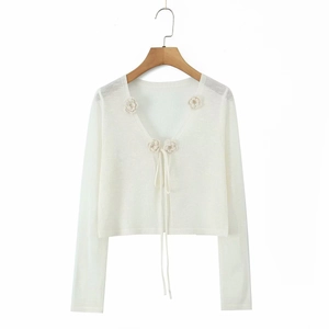 White long-sleeve knit cardigan featuring a V-neck, ribbon tie, and floral appliques