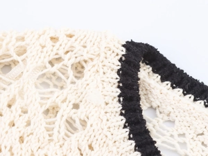 Dettaglio ravvicinato della trama a maglia traforata con finiture nere e bianche