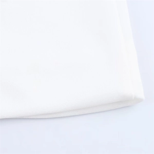 Macro shot of the white knitted fabric texture and soft folded hem of this backless dress