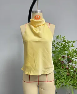 Dettaglio del top all'americana senza maniche in raso giallo chiaro su un manichino