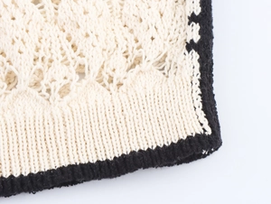 Dettaglio del tessuto in maglia jacquard traforata bianca con bordo a costine nero