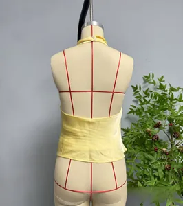 Dettaglio del top satinato con scollo all'americana, schiena scoperta e bottoni di perle