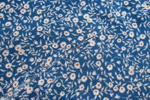 Detailaufnahme von blauem Blumenmuster und Nähten an einem Kleid mit eckigem Ausschnitt