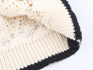 Vista macro di maglia a uncinetto traforata bianca con bordo a costine nero