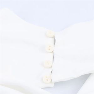Detailed macro view of four round white buttons on a halter backless long white dress