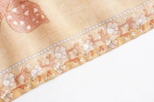 Macro shot of warm brown floral fabric detailing the fine rolled hem and flower print