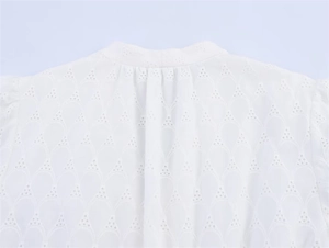 Detailed macro view of white Broderie Anglaise cotton fabric with hollow embroidery details