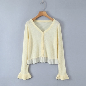 Pale yellow V-neck cardigan with white ruffle hem and black contrast piping trim