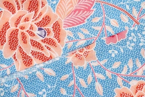 Gros plan du tissu à imprimé floral avec fleurs orange et coutures précises sur la robe