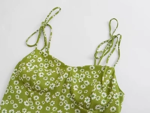 Detailed close-up of grass green floral camisole top with white daisy print and pleats